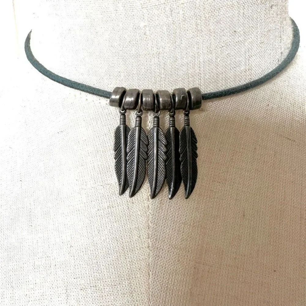 Silver tone four leaf pendant necklace on blue cord